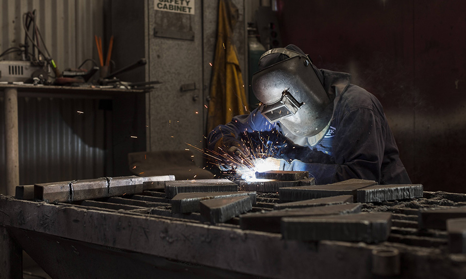 Welder wearing protective gear in factory. Image shot by Dale Travers Photography in Brisbane for the industrial photography suite of images.